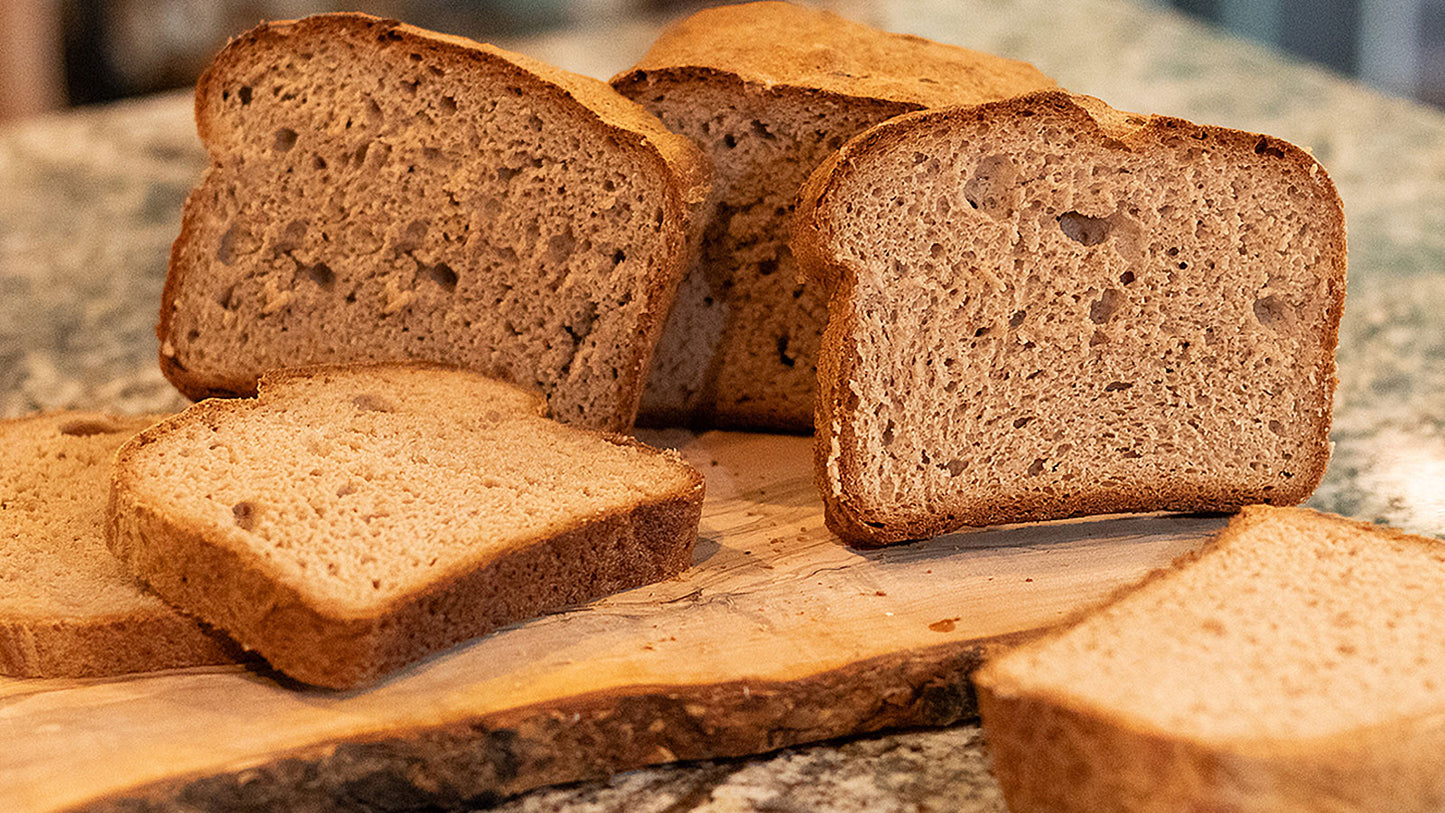 Slices of gluten-free bread on a wooden cutting board