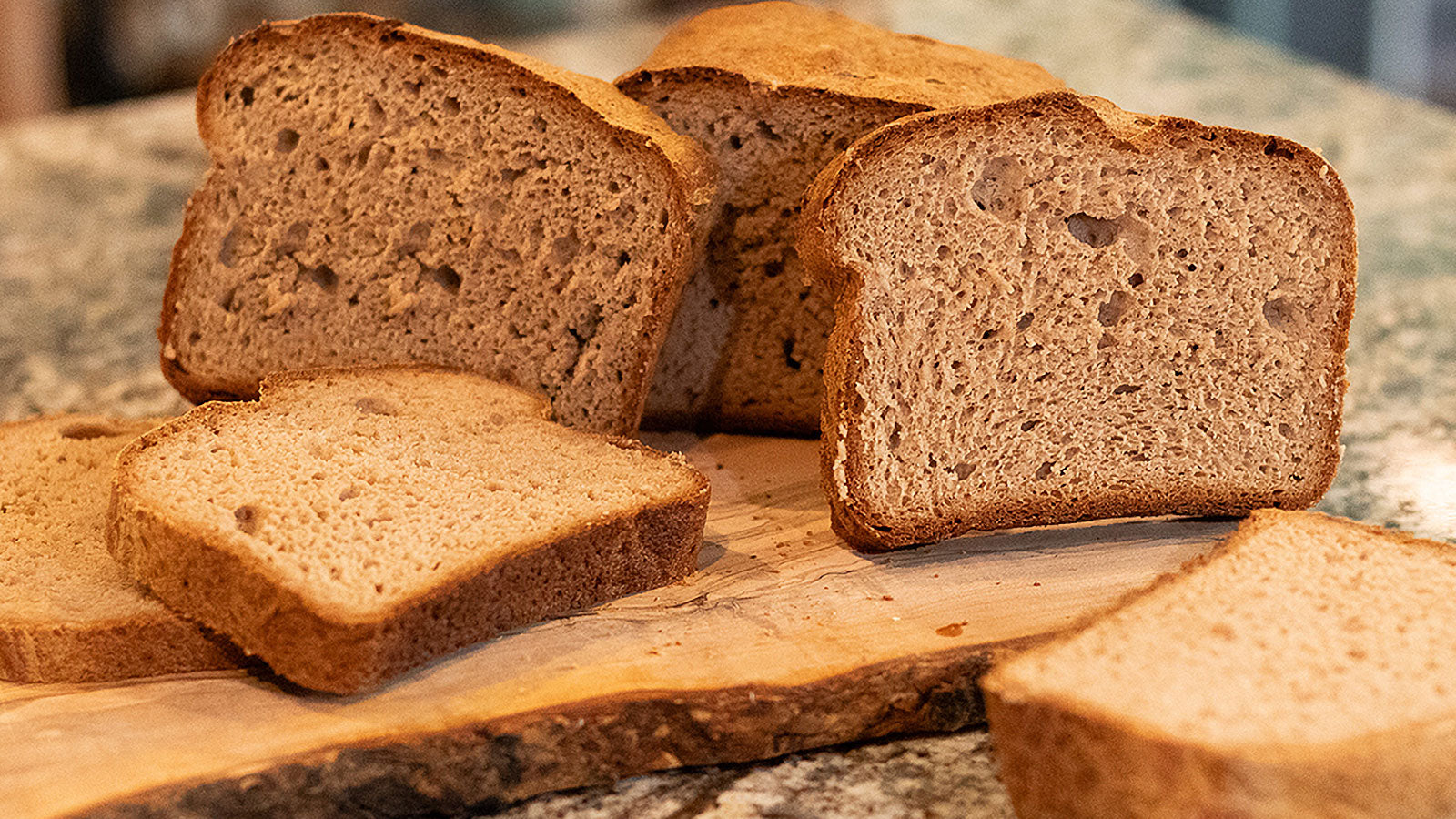 Slices of gluten-free bread on a wooden cutting board